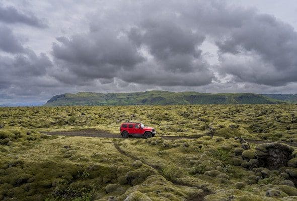 Red Jeep driving through Eldhraun lava fields