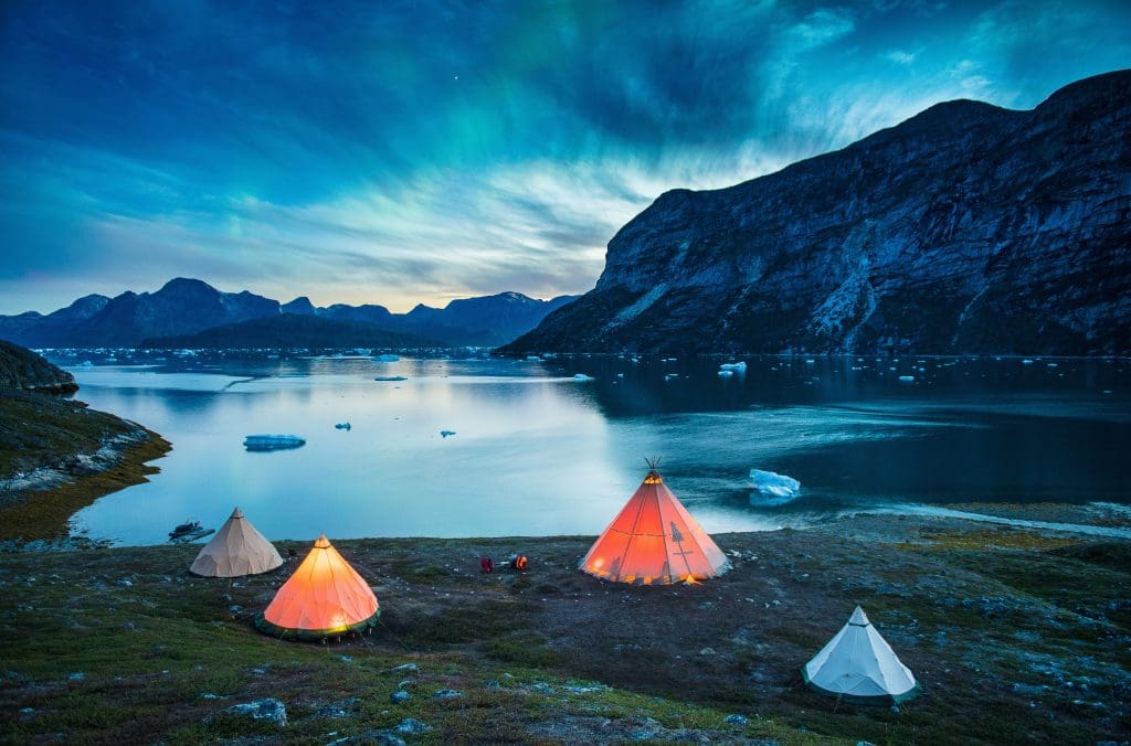 glamping_tents_beside_water_at_dusk