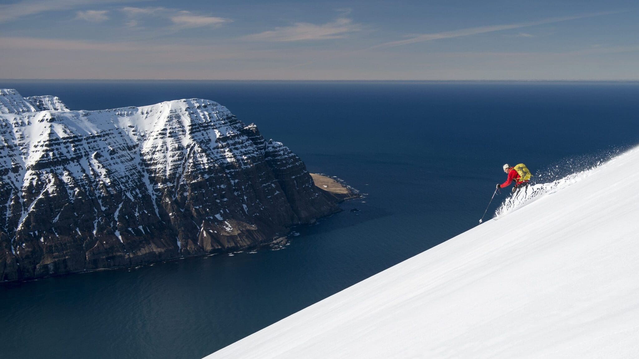 skiier_on_snowy_hill_with_sea_in_background