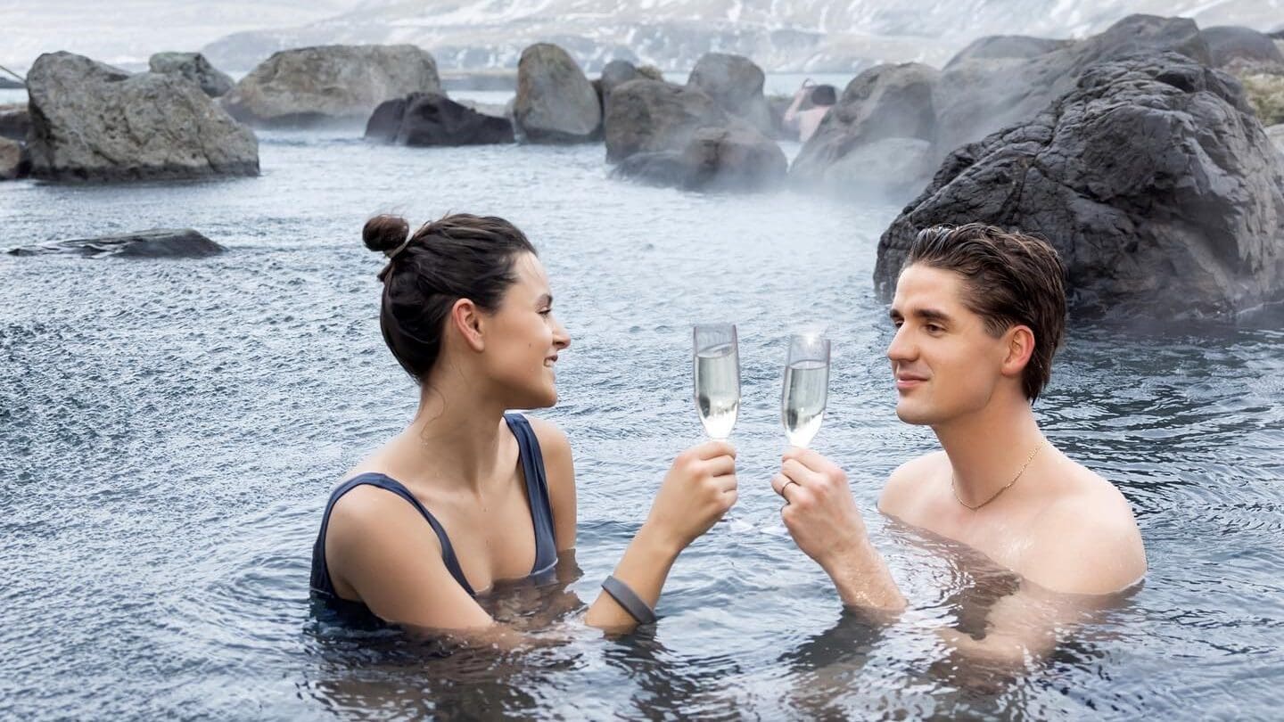 couple_with_champagne_in_hot_spring_hvammsvik