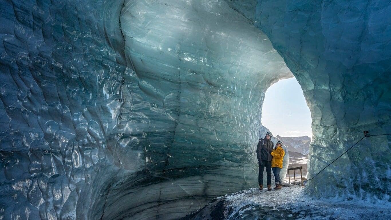 people_walking_through_hole_in_glacier